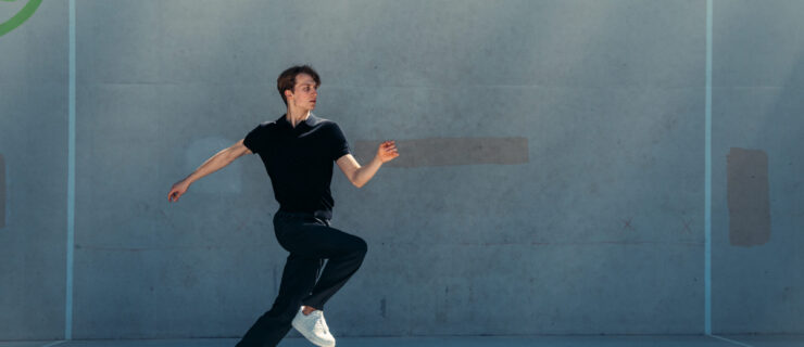 Vsevolod Maievsky in black outfit and white sneakers running mid-shot