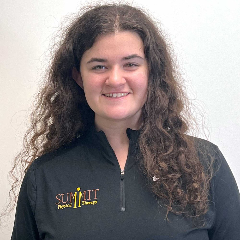 Jennifer Coviello's headshot. A white woman with brown curly hair wearing a black jacket.