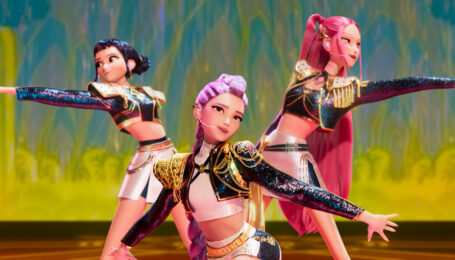 A still from "KPop Demon Hunters" showing three female K-Pop stars performing onstage.