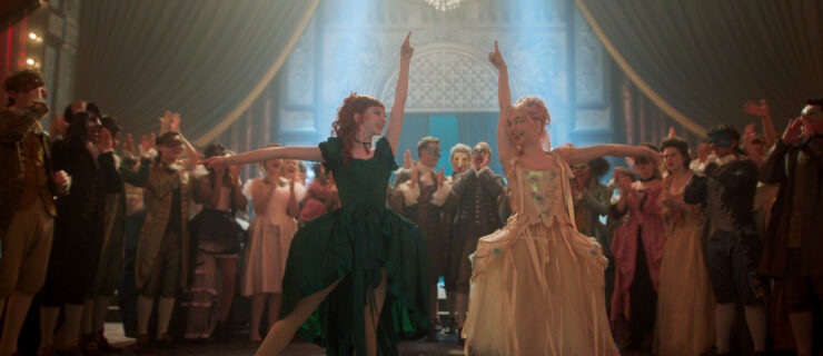 On the set of "Wednesday," two dancers in Venetian dress point up and to the side, hips bumping in toward another in tendu a la seconde, as they perform for a crowd in an ornate ballroom.