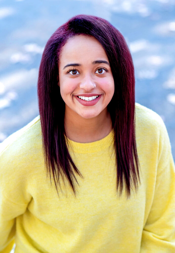 Kiera Letts' headshot. She wears a yellow long sleeve shirt. 