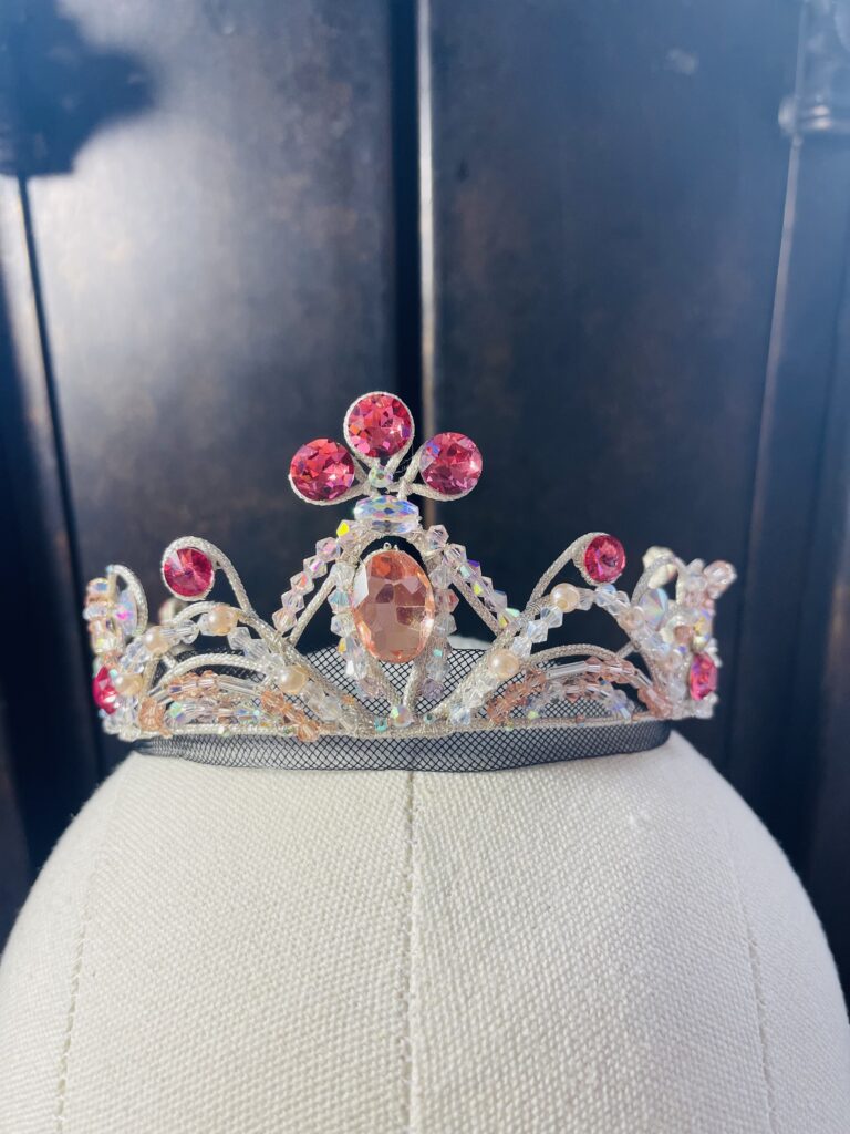 A ballet costume tiara with pink, white, and clear jewels.