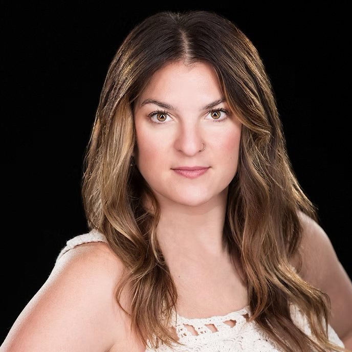 Kelsay Stephensen's headshot. She has long brown hair and wears a white tank top.