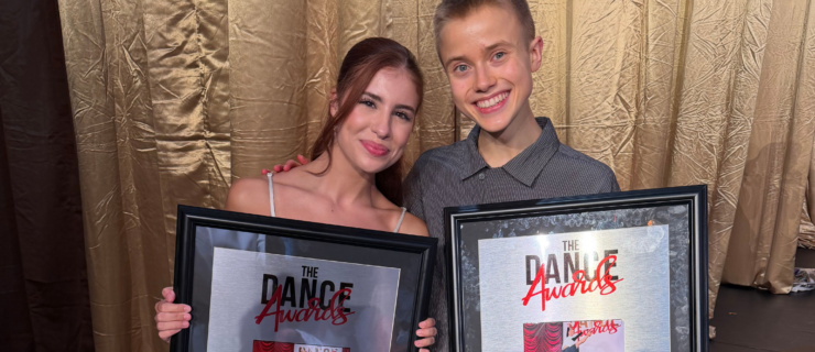 Cameron Voorhees and Ian Stegeman pose together in formal attire holding their respective dance awards. Behind them is a shimmery gold curtain.