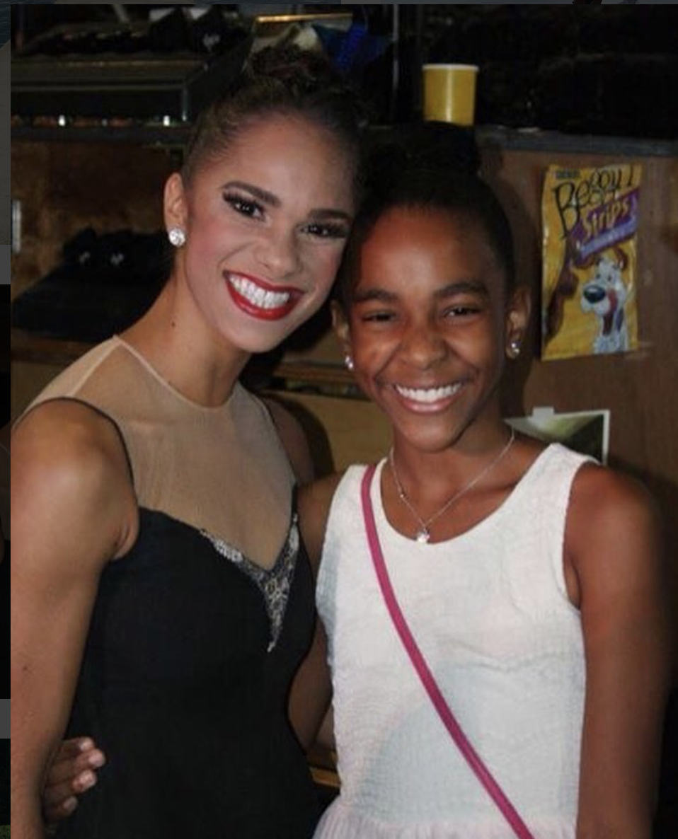 Misty Copeland and a young Nia Faith pose together for a photo wearing formal dresses.
