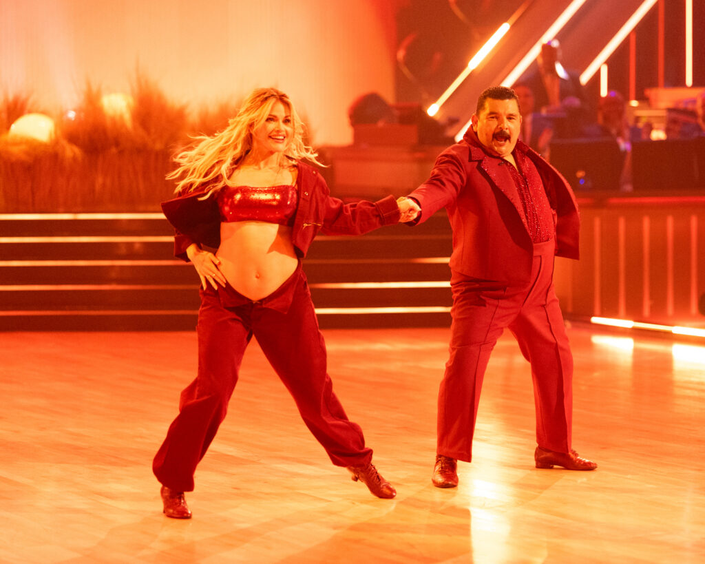Witney Carson and Guillermo hold hands in the middle, their other hands on their hips, as Rodriguez spins Carson out to the side.