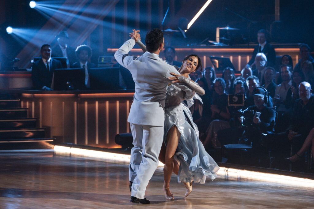 Costumed in powder blue evening wear, Alan Bersten and Jenna Dewan waltz in frame with a slight lean to the right.