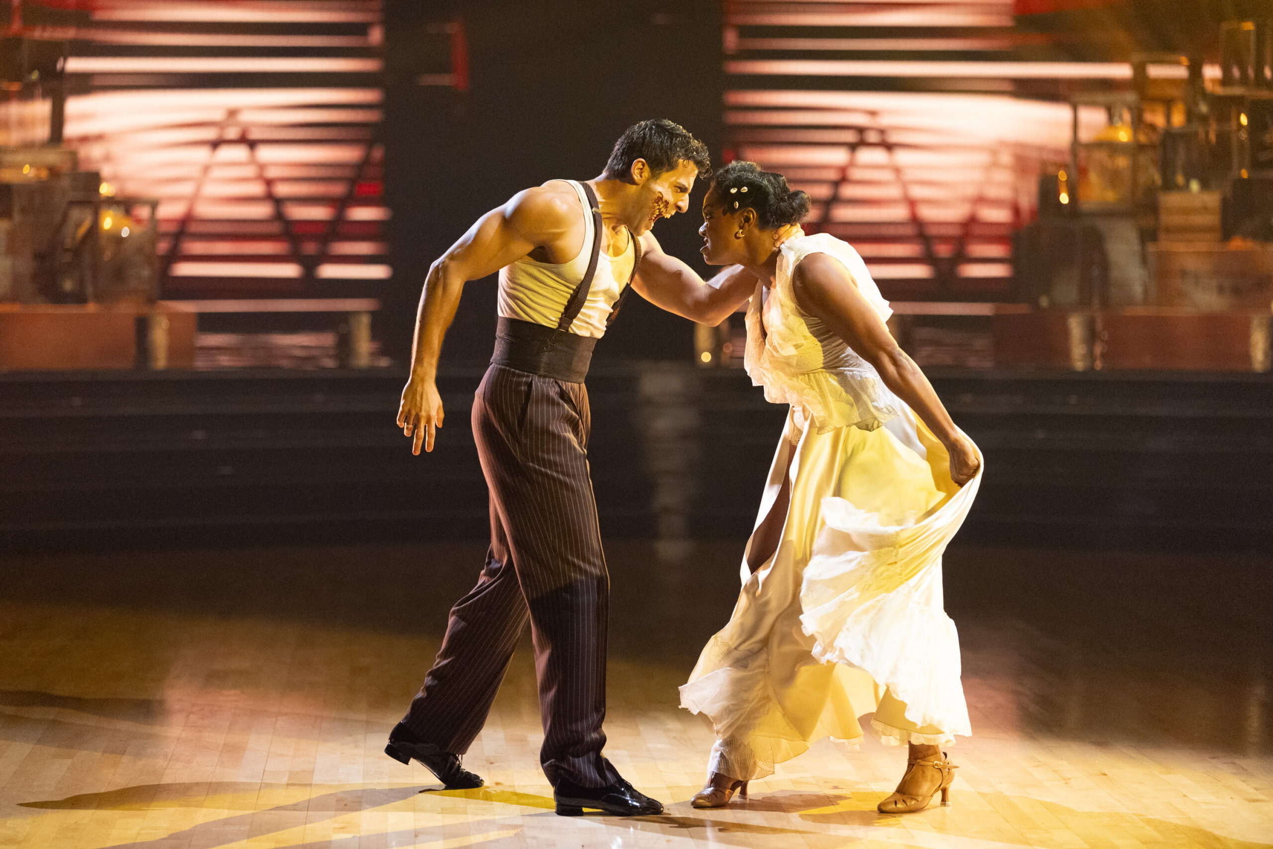 Jan Ravnik and Tatyana Ali face each other, snarling, as Ravnik holds Ali across the back of her neck. He wears special effects makeup that makes it look like his cheek has been ripped off, exposing sharp teeth.