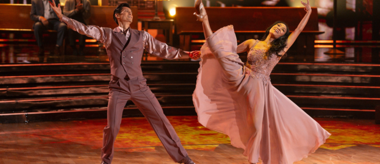 Harry Shum Jr. and his wife, Shelby Rabara, perform in mauve evening-style costumes, holding hands as Shum Jr. steps out and Rabara leans back with her inside leg in a high battement.